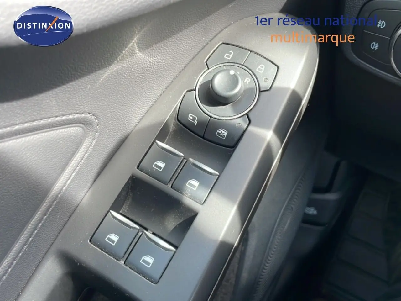 Gros plan sur les commandes de lève-vitres et rétroviseurs côté conducteur de la Ford Focus SW 2023, intérieur noir.
