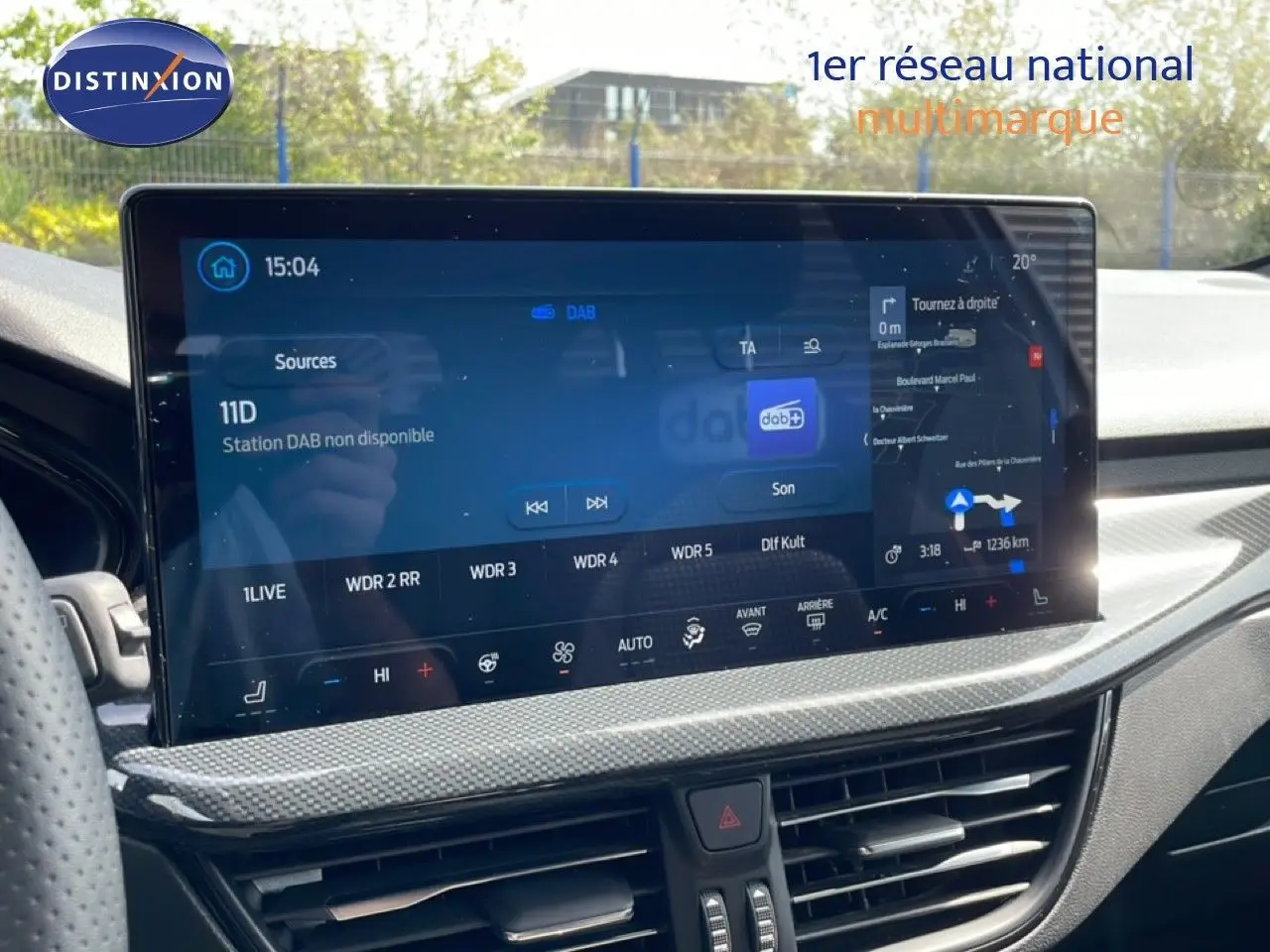 Vue intérieure du tableau de bord de la Ford Focus SW 2023, écran tactile large avec navigation et climatisation.