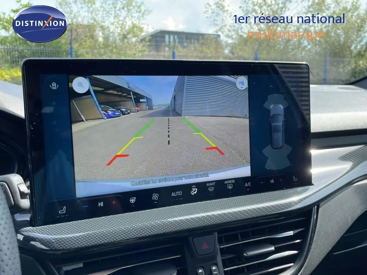 Écran tactile intérieur montrant la caméra de recul d'une Ford Focus SW gris lunaire, tableau de bord moderne.