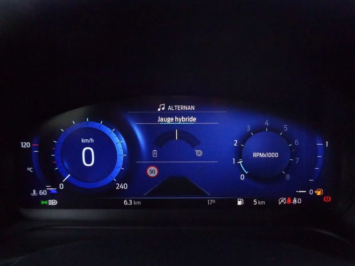 Tableau de bord numérique bleu du Ford Puma 1.0 EcoBoost MHEV 155ch, affichant vitesse, régime et jauge hybride.