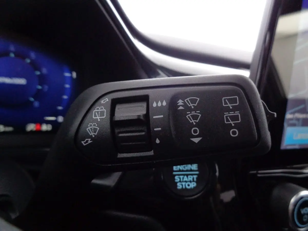 Gros plan sur la commande des essuie-glaces du Ford Puma noir agate métal, avec tableau de bord et bouton start visible.