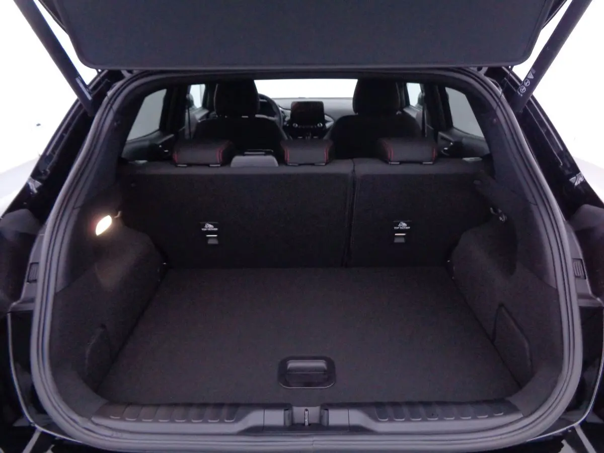 Coffre ouvert en vue arrière d'une Ford Puma noir agate métal, montrant l'espace de chargement et les sièges arrière.