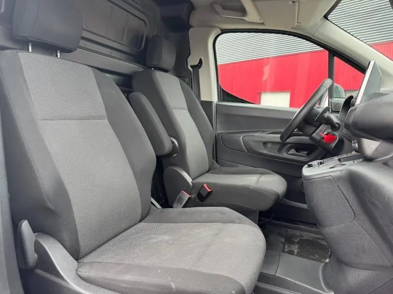 Vue intérieure côté conducteur du Citroën Berlingo Fourgon 2020, sièges tissu gris et tableau de bord noir.