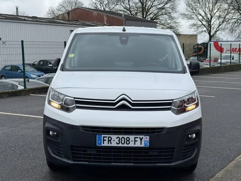 Vue avant d'un Citroën Berlingo Fourgon blanc Banquise avec phares allumés et plaque d'immatriculation française.