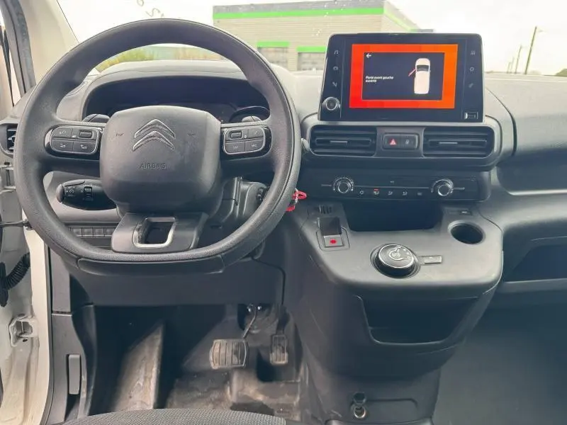 Intérieur du Citroën Berlingo Fourgon blanc, vue du poste de conduite avec volant multifonction et écran tactile central.