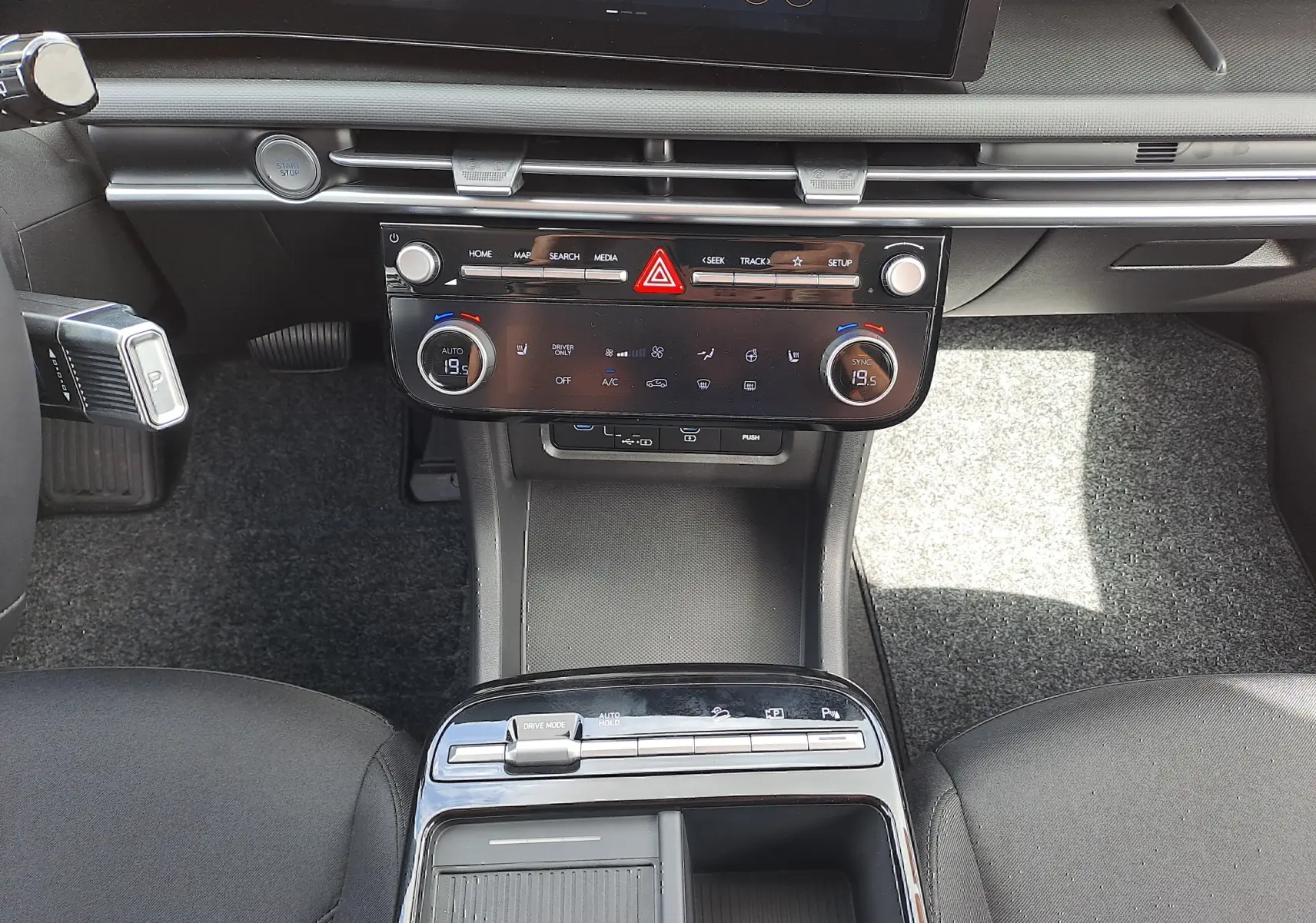 Vue rapprochée du tableau de bord et console centrale du Hyundai Tucson 2025, intérieur noir avec commandes digitales.