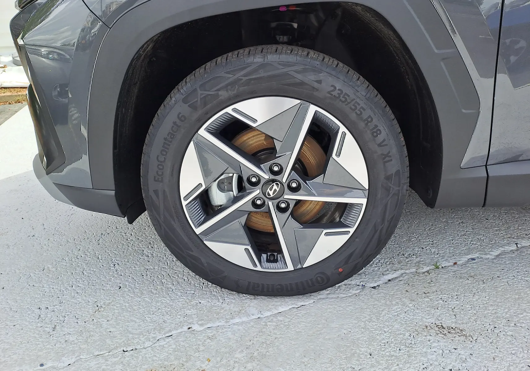 Gros plan sur la roue avant gauche du Hyundai Tucson 2025 gris Ecotronic avec jante alliage à design géométrique.