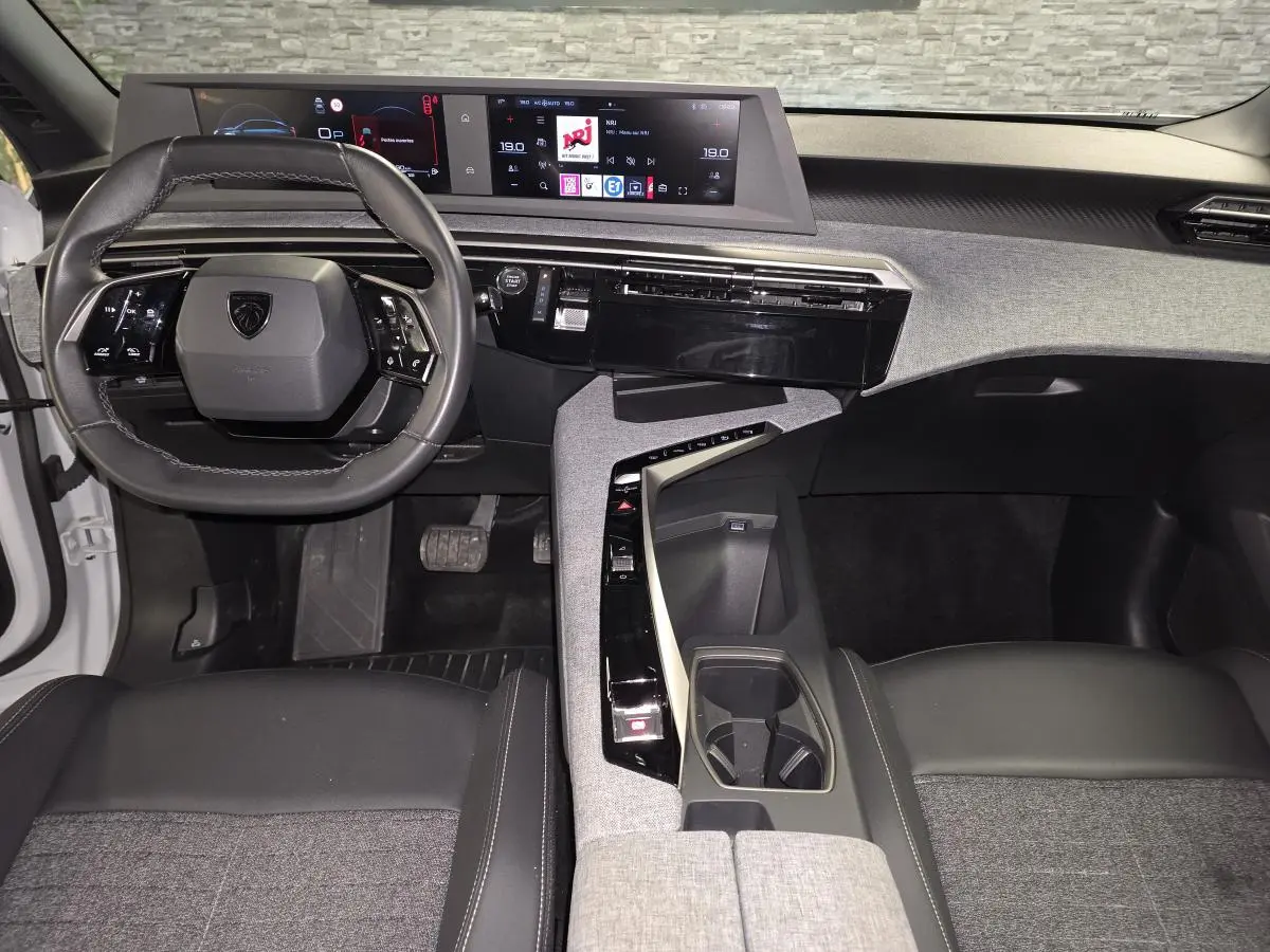 Intérieur avant du Peugeot 3008 2025, vue du poste de conduite avec volant compact et double écran HD panoramique.