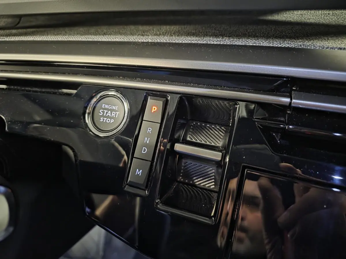 Gros plan sur la console centrale noire laquée du Peugeot 3008 blanc, avec bouton start/stop et sélecteur de boîte auto.