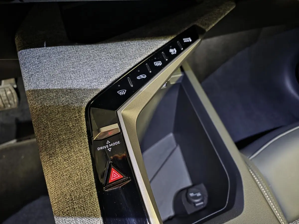 Détail de la console centrale du Peugeot 3008 blanc 2025, avec bouton Drive Mode et décor tissu gris chiné.