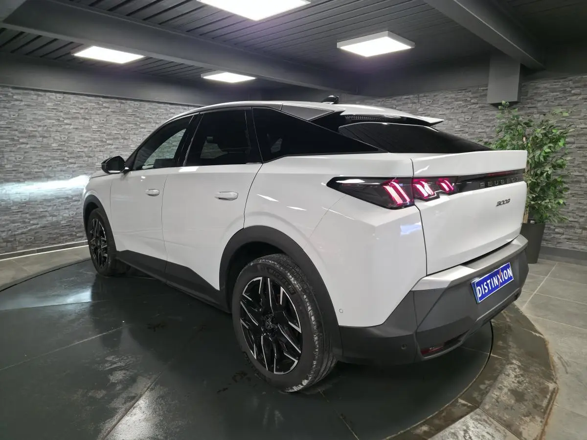 Peugeot 3008 blanc vue 3/4 arrière droit, jantes alliage noires et feux arrière LED 3 griffes visibles.