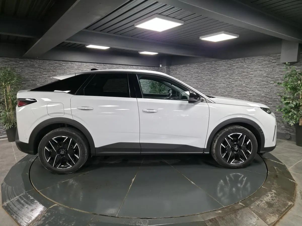 Peugeot 3008 blanc en vue profil côté gauche, avec jantes alliage noires et protections noires sur passages de roues.