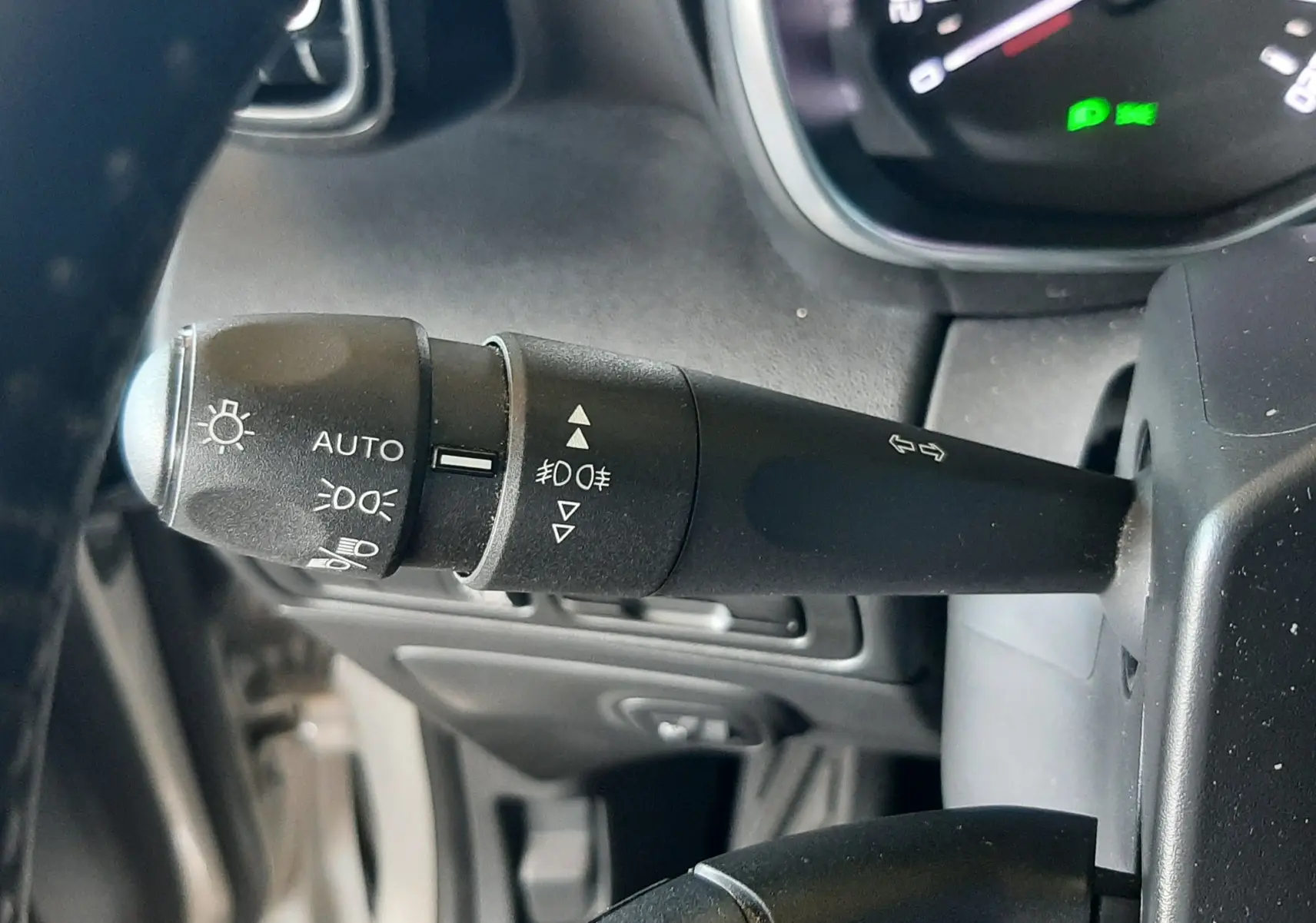 Gros plan sur les commandes de phare et régulateur de vitesse du tableau de bord d'une Citroën C3 Aircross 2021.