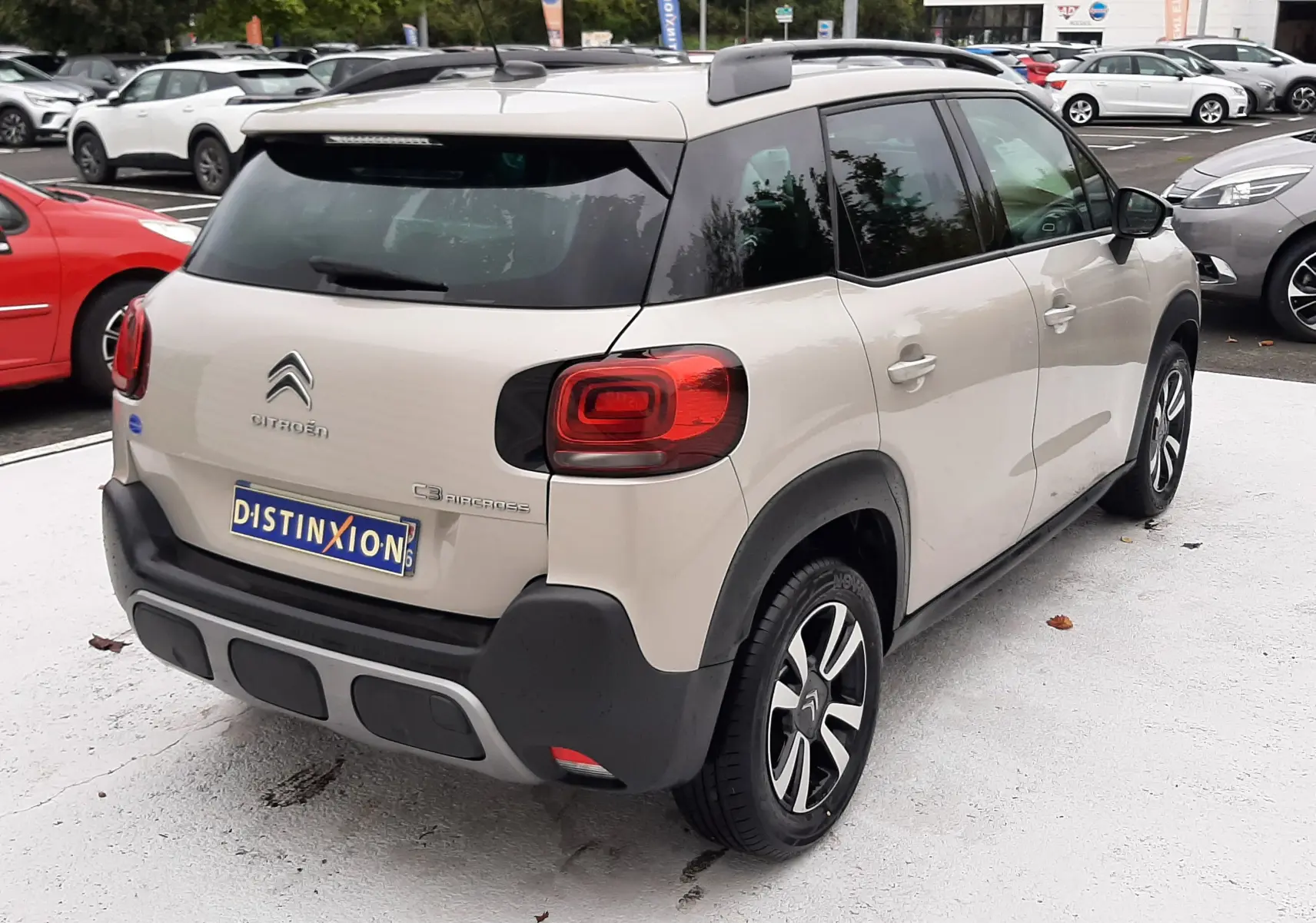 Vue 3/4 arrière droite d'une Citroën C3 Aircross sable métal avec toit noir et jantes alliage distinctives.