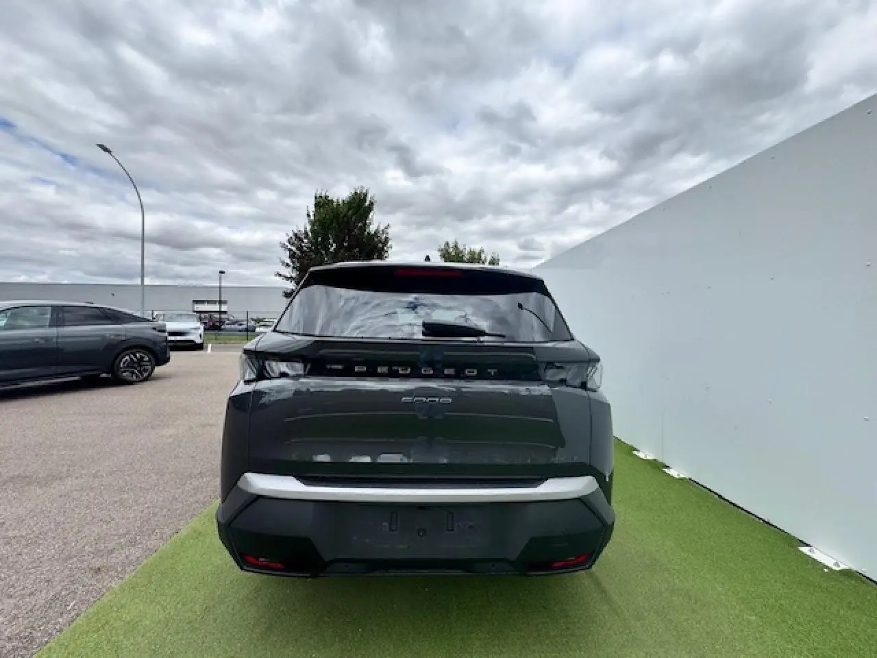 Vue arrière d'un Peugeot 5008 gris titane avec toit noir, feux arrière à LED 3 griffes et hayon motorisé.