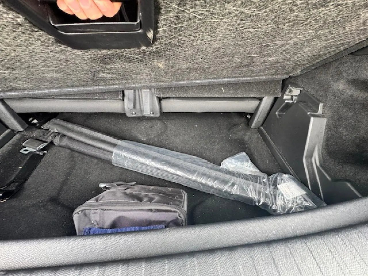 Coffre arrière du Peugeot 5008 gris titane, vue intérieure montrant un rangement sous la banquette arrière.