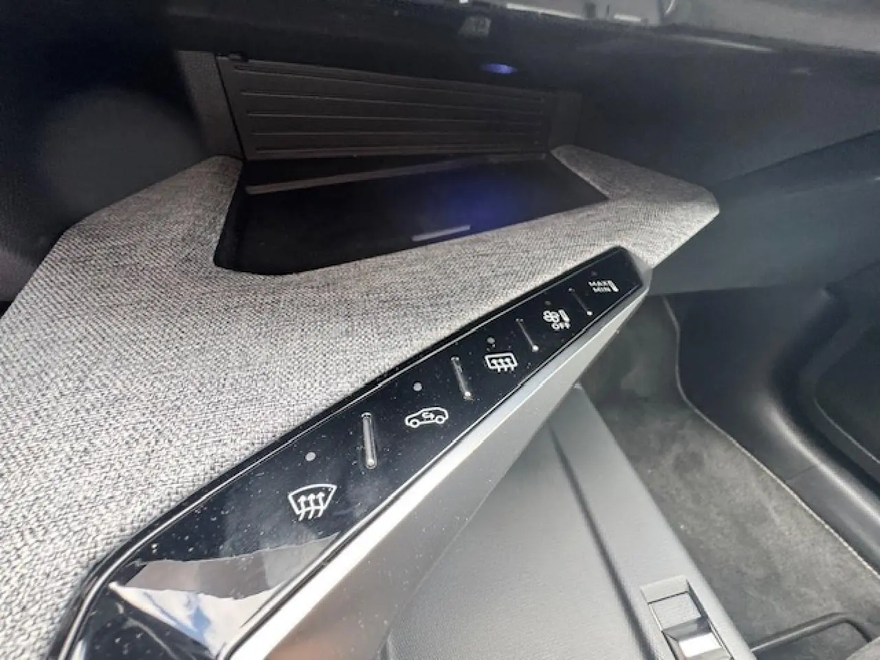 Gros plan sur la console centrale du Peugeot 5008 gris titane, montrant les commandes tactiles de désembuage et circulation d'air.