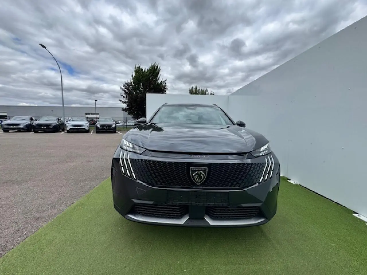 Vue frontale du Peugeot 5008 gris titane avec toit noir, mettant en valeur sa calandre et ses phares LED griffés.