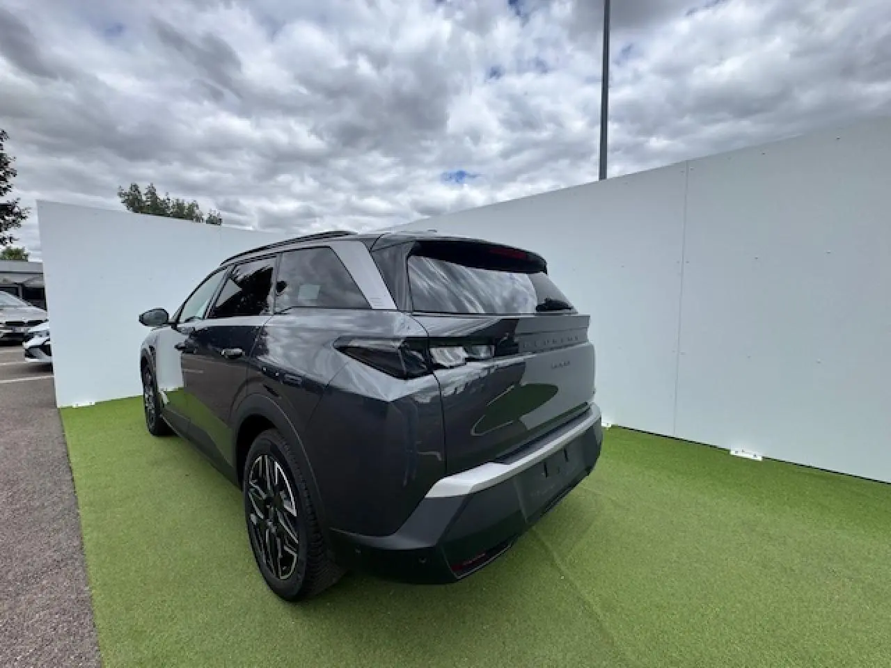 Peugeot 5008 gris titane avec toit noir, vue 3/4 arrière droit, jantes alliage noires et vitres teintées.