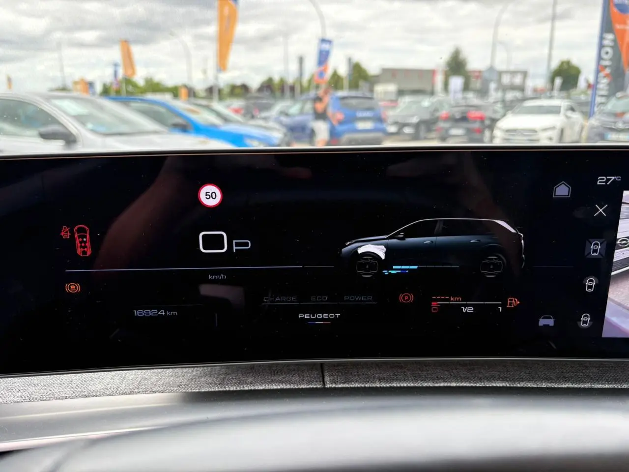 Affichage numérique du tableau de bord Peugeot 5008 hybride, montrant un véhicule gris en profil droit sur écran panoramique.