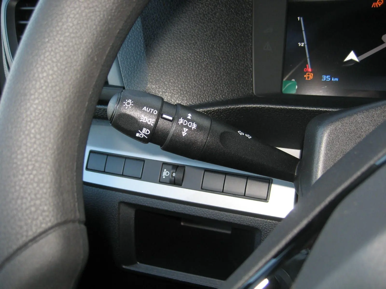 Gros plan sur la manette de commandes d'éclairage à gauche du volant dans l'habitacle du Peugeot Expert Fourgon blanc.