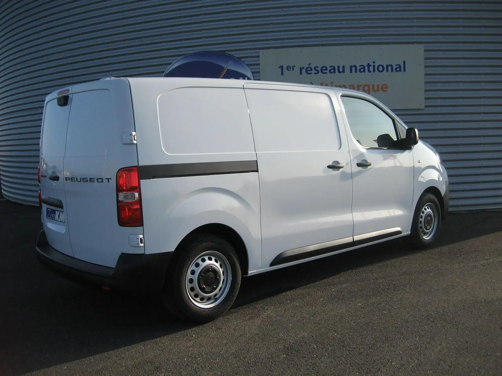 Peugeot Expert Fourgon blanc vu en 3/4 arrière côté droit, avec portes latérales et jantes acier simples.