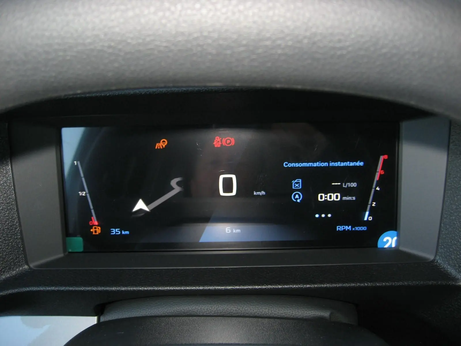 Tableau de bord numérique du Peugeot Expert Fourgon blanc 2025 affichant vitesse zéro et consommation instantanée.