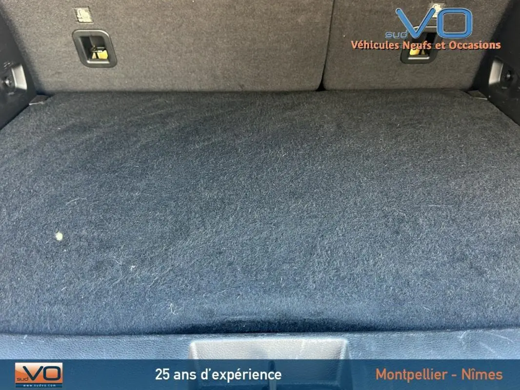 Espace de coffre noir du Jeep Renegade 2024, finition Summit, montrant la moquette et les fixations arrière.