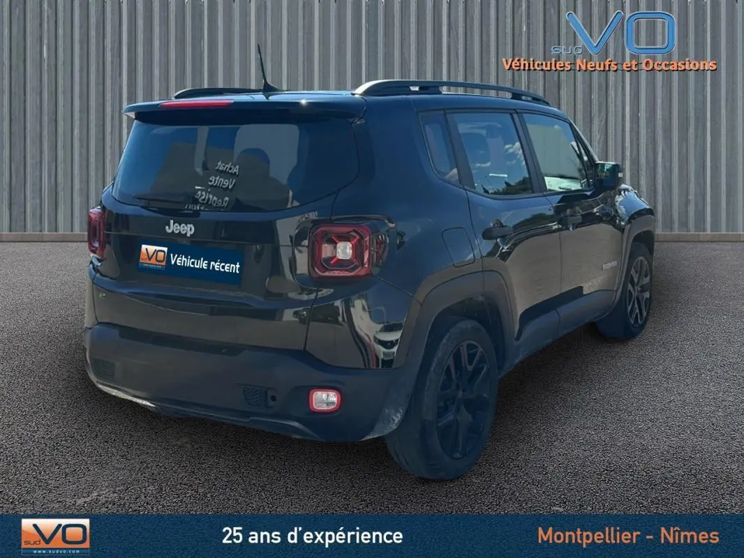 Jeep Renegade noir vue 3/4 arrière droit, avec barres de toit et jantes alliage 18 pouces sur sol goudronné.