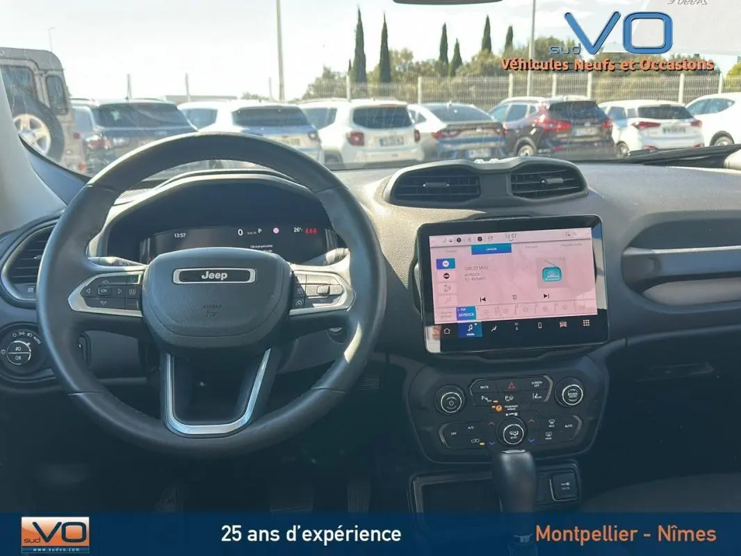 Vue intérieure du tableau de bord du Jeep Renegade 2024 noir, avec écran tactile central et volant multifonction.