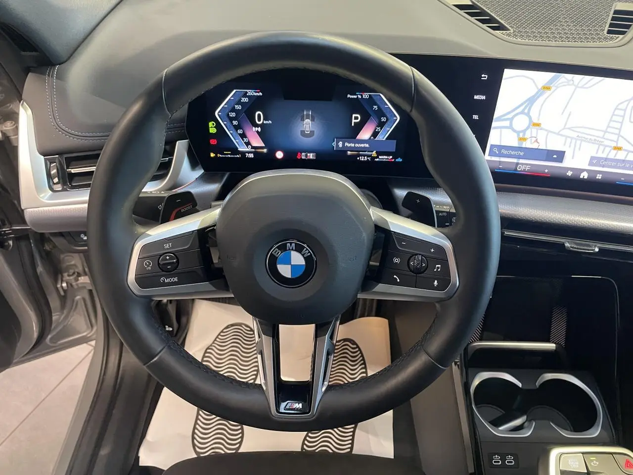 Vue intérieure centrée sur le volant M cuir noir et le combiné numérique du BMW X1 xDrive 20d 2024 en Spacesilber Metallic.
