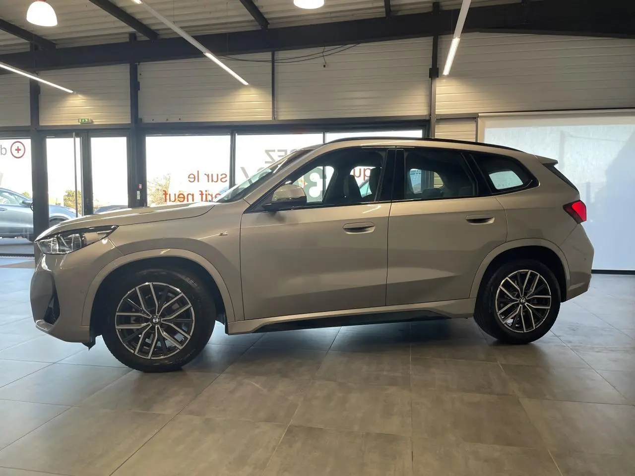 BMW X1 xDrive 20d 2024 en Spacesilber Metallic, vue profil côté gauche avec jantes alliage 18 pouces M Sport.