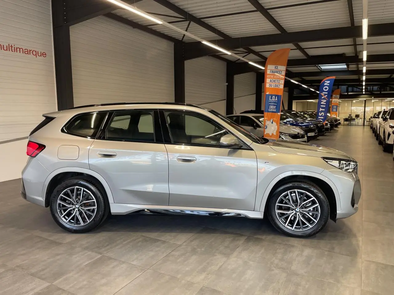 BMW X1 xDrive 20d 2024 en Spacesilber Metallic, vue de profil côté gauche avec jantes alliage 18" et finitions M Sport.