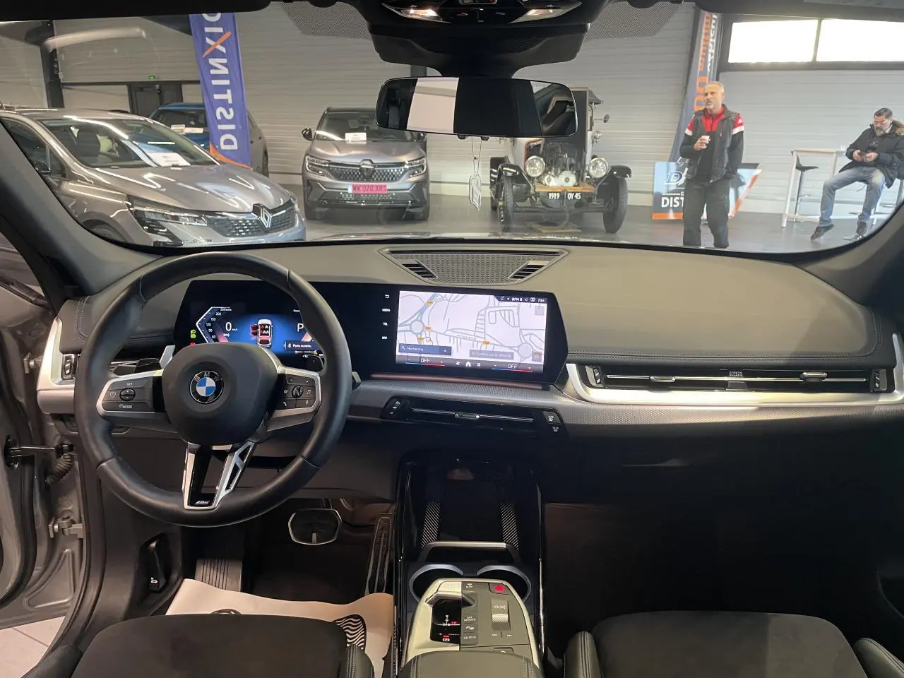 Vue intérieure avant du BMW X1 xDrive 20d 2024 en Spacesilber Metallic, tableau de bord numérique et volant M cuir.