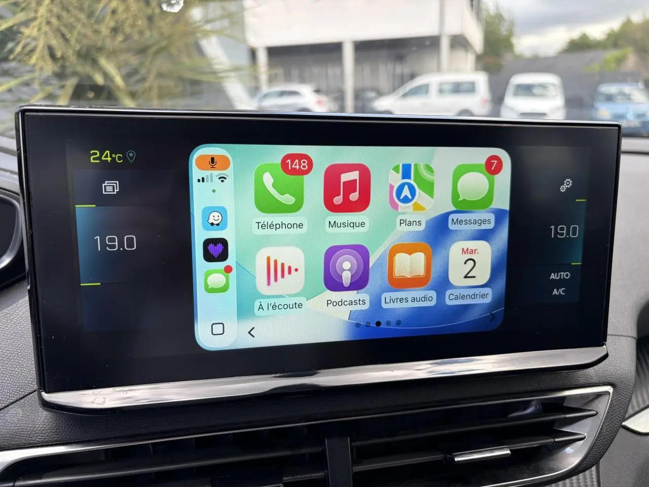 Écran tactile central du Peugeot 3008 Plug-in Hybrid affichant Apple Carplay avec commandes climatisation à 19°C.