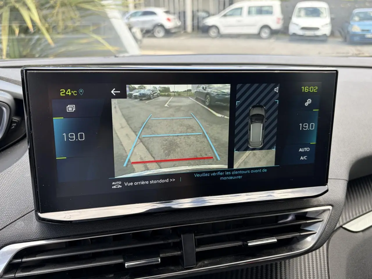 Écran tactile intérieur du Peugeot 3008 noir Perla montrant la caméra de recul et l'affichage de la climatisation à 19°C.