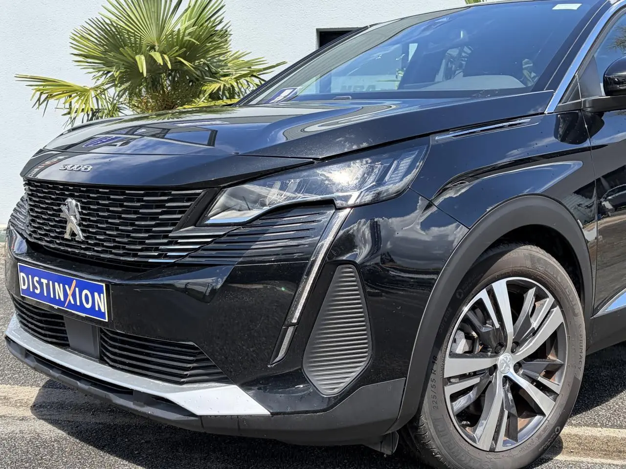 Vue 3/4 avant droite du Peugeot 3008 Plug-in Hybrid noir Perla avec calandre distinctive et jantes alliage bi-ton 18 pouces.