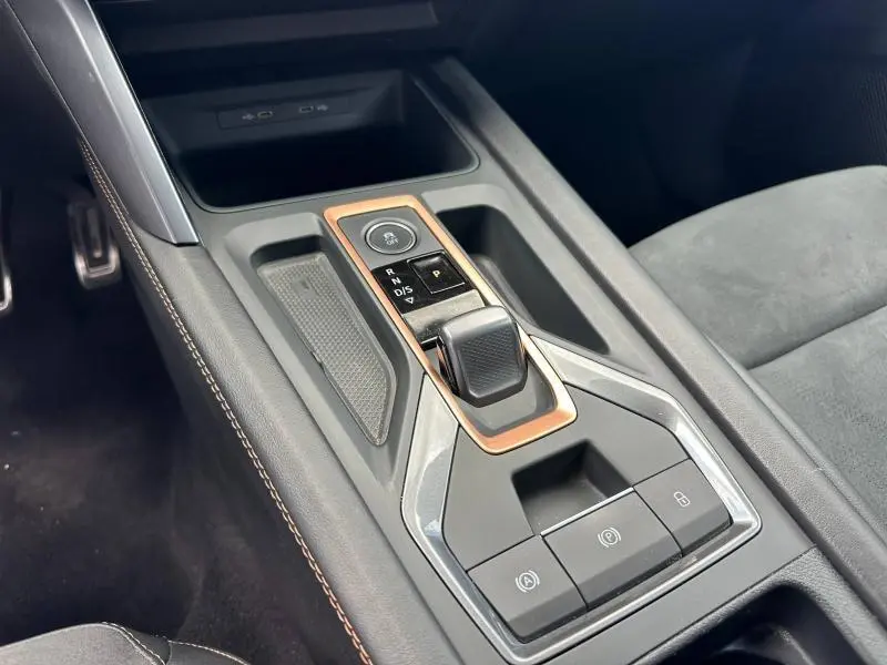 Vue rapprochée de la console centrale noire avec levier de vitesses automatique et surpiqûres cuivrées dans une CUPRA Formentor blanche.