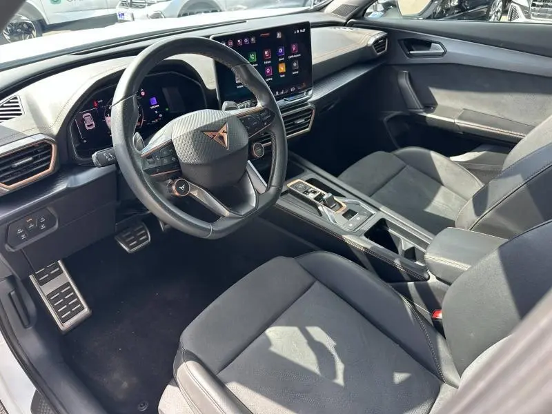 Vue intérieure côté conducteur du CUPRA Formentor 1.5 eTSI Hybrid avec volant cuir multifonction et écran tactile.