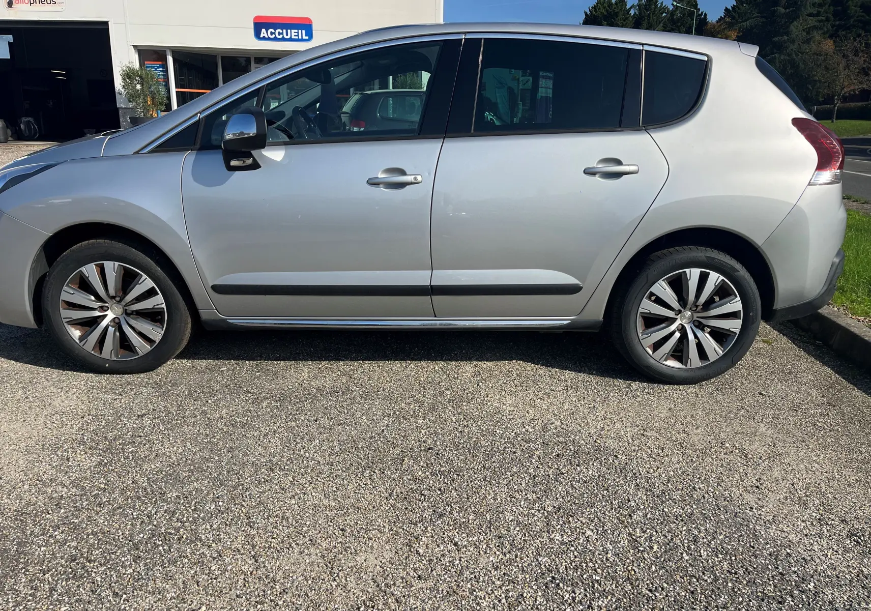 Profil côté gauche d'un Peugeot 3008 gris clair de 2014, finition Allure avec jantes alliage et vitres teintées.