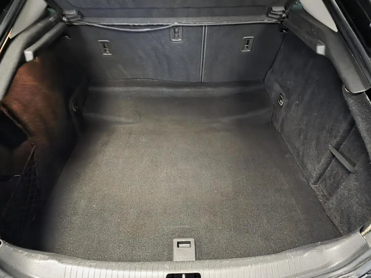 Coffre ouvert vu de face, intérieur noir spacieux et propre de l'Opel Insignia 2016 finition Cosmo.