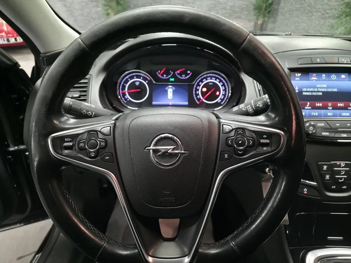 Volant cuir noir avec commandes intégrées et tableau de bord numérique d'une Opel Insignia 2016 vue de face intérieure.