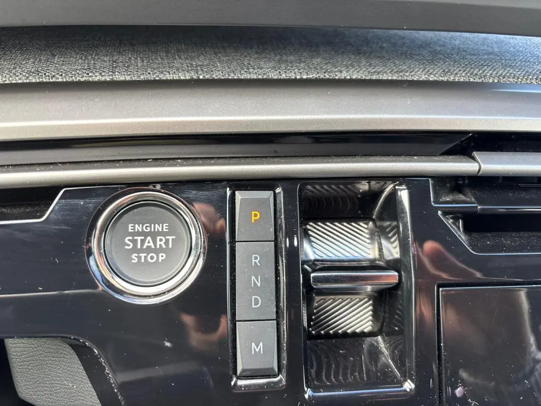 Gros plan sur la console centrale noire du Peugeot 3008 Hybrid 145 e-DCS6 Allure avec bouton start/stop et commandes de boîte auto.