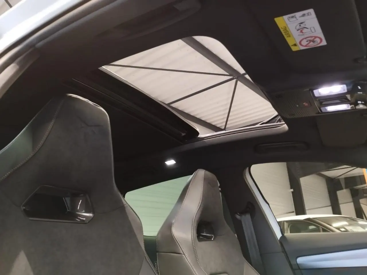 Vue intérieure des sièges baquets suédine noirs avec surpiqûres cuivrées et toit ouvrant panoramique du CUPRA Formentor blanc