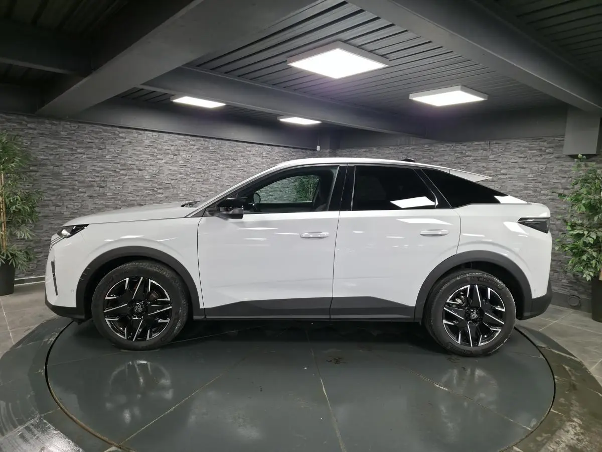 Peugeot 3008 blanc vue de profil côté gauche, jantes alliage noires et toit noir contrasté dans un showroom.