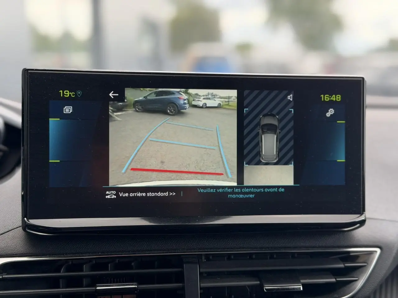 Écran tactile du Peugeot 3008 Plug-in Hybrid montrant la caméra de recul et l’aide au stationnement en vue intérieure.