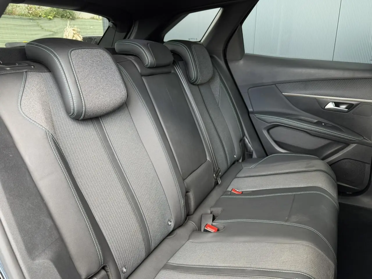 Vue intérieure côté droit des sièges arrière en tissu et cuir noir du Peugeot 3008 Plug-in Hybrid 2024.