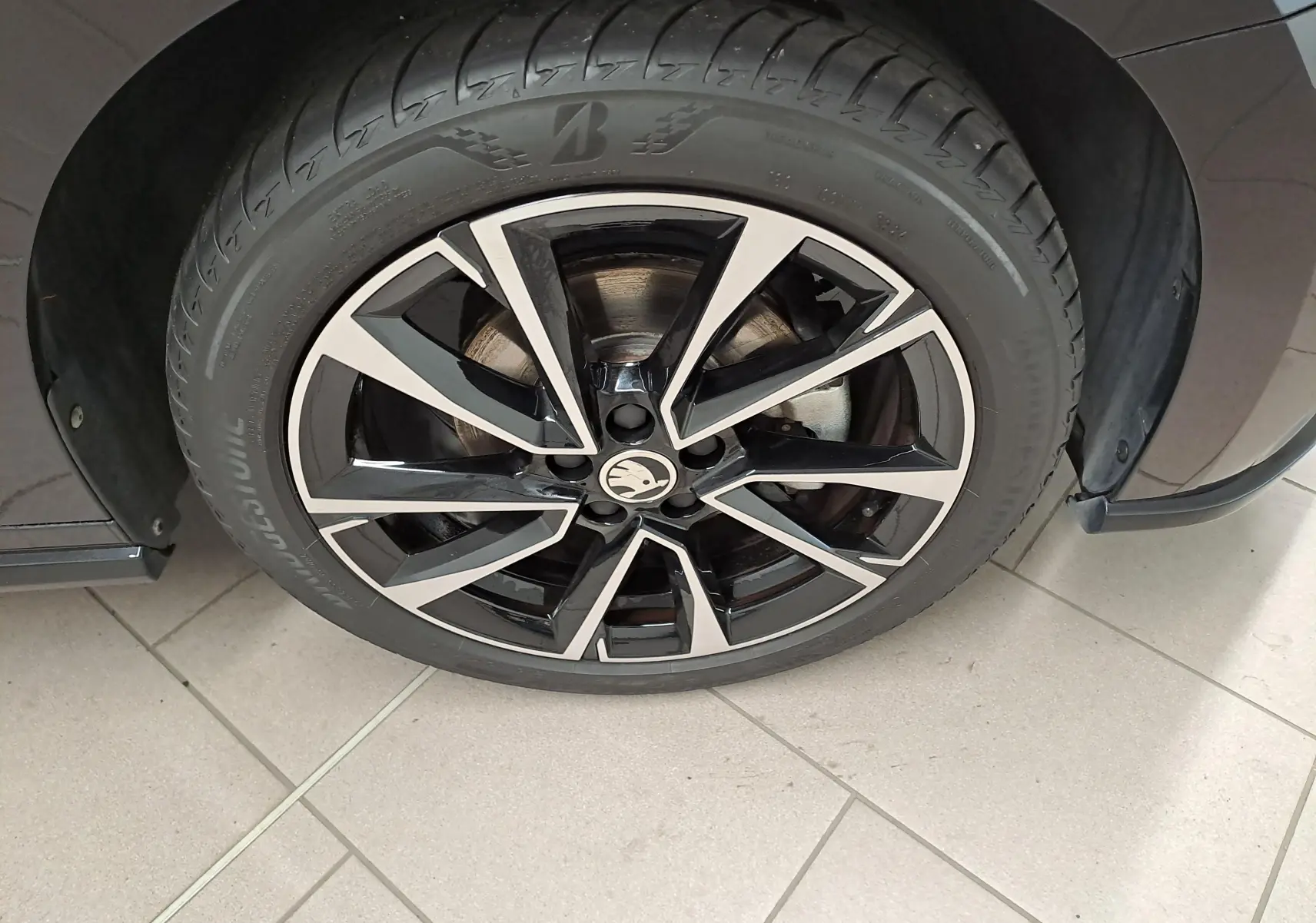 Gros plan sur la roue avant droite de la Skoda Fabia 2024 en Noir Magic Nacré avec jante alliage noire et argentée.