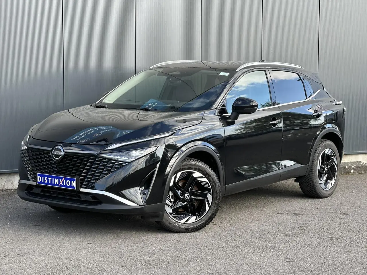 Nissan Qashqai 2025 noir nacré en 3/4 avant droit, avec jantes alliage noires et toit panoramique.