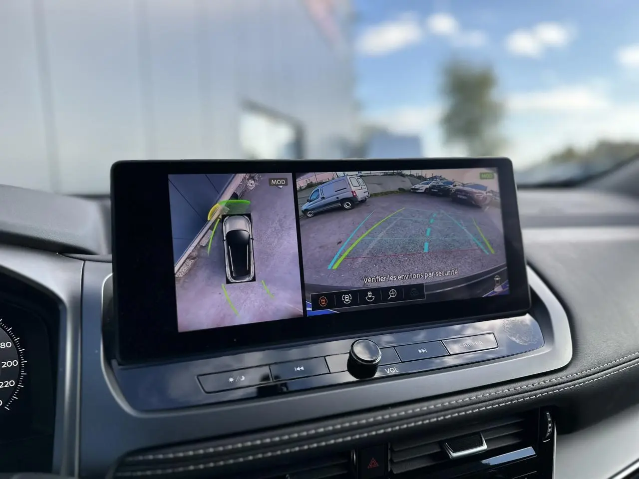 Écran central du Nissan Qashqai 2025 montrant la caméra de recul et la vue 360° du véhicule noir nacré en stationnement.